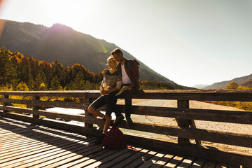 Austria, Alps, couple on a hiking trip having a break on a bridge