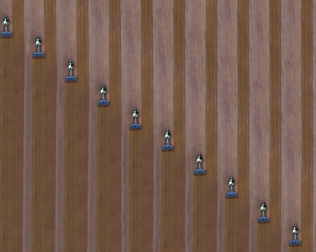 Russia, Aerial view of tractors plowing brown field