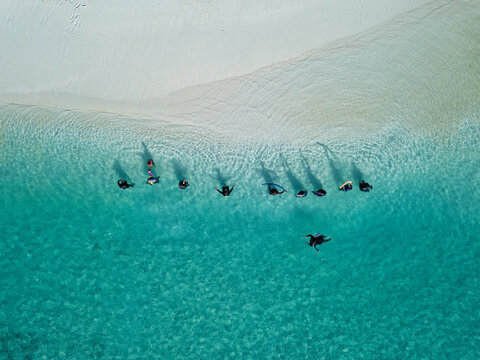Women in traditional muslim clothes at tropical beach, aerial view