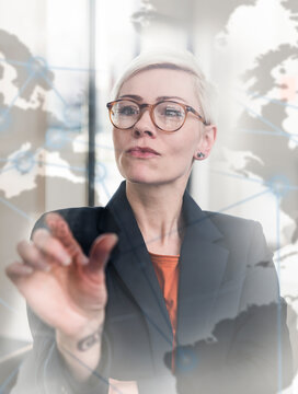 Businesswoman touching virtual glass wall in office