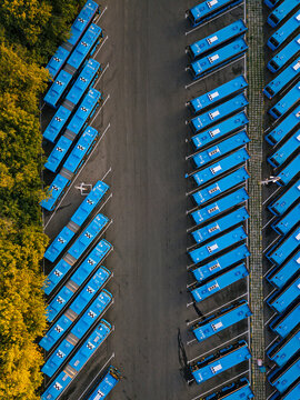 Aerial view of parking lot filled with blue buses