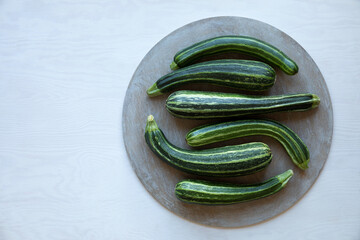 Few striped courgette vegetables on round circle table. Flat lay view.