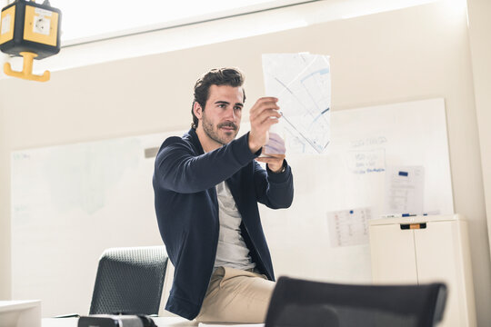 Young businessman in office holding foil of a blueprint
