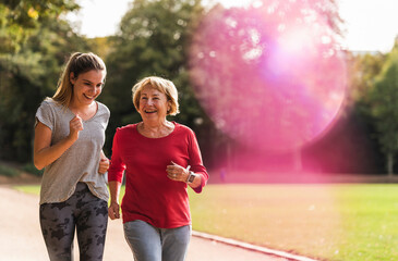 Granddaughter and grandmother having fun, jogging together in the park