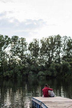 Young couple embracing on jetty at a remote lake