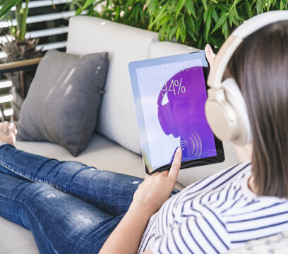 Young woman with tablet awith smart home control functions and headphones