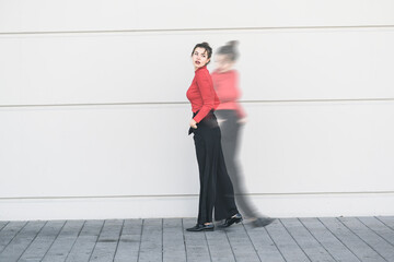 Digital composite of young woman moving in front of a wall