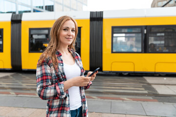 Portrait of a smiling woman in the city with a tram in the background, Berlin, Germany - obrazy, fototapety, plakaty