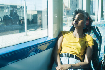 Young woman with headphones relaxing in a train