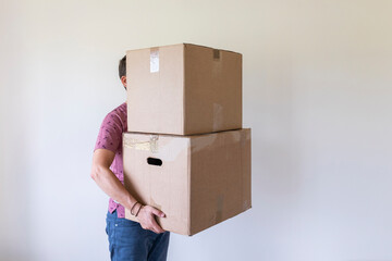 Man moving into new home carrying cardboard boxes