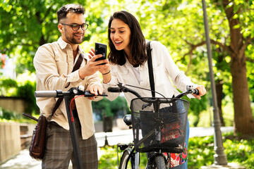 Happy funny couple with bicycle in the park. Loving couple enjoying together outdoors..