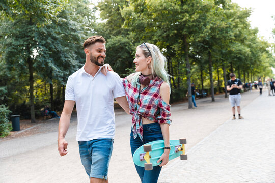 Happy young couple walking in a park