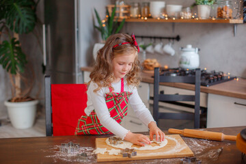 little girl making cookies for christmas in the kitchen