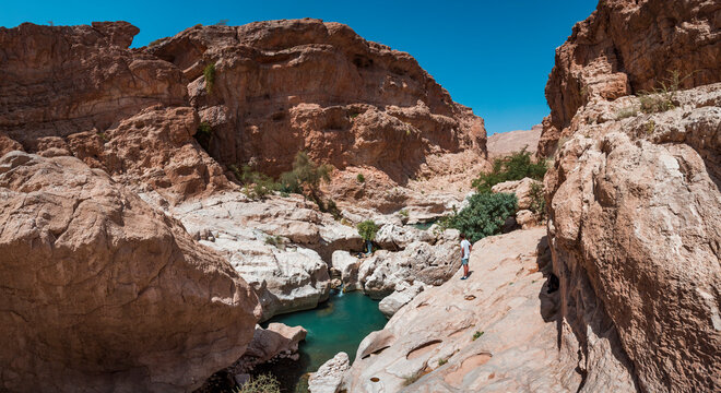 Tourist looking at Wadi Bani Khalid, Oman