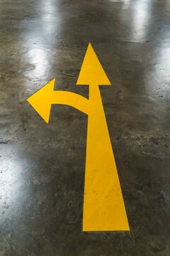 Yellow arrow on empty parking lot at night