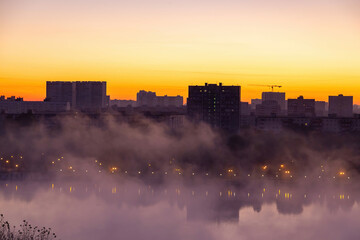 Beautiful orange texture of a misty city on the banks of the river