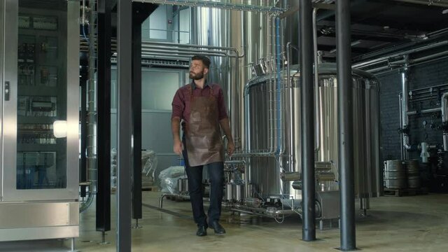 Young male brewer works at a modern brewery