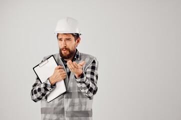 male builder with documents and drawings blueprints light background