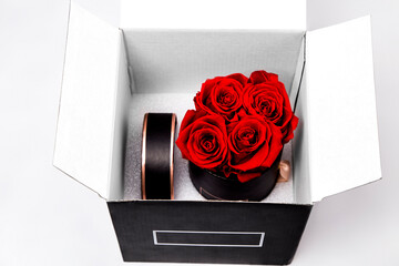 Elegant black Flower box with red roses. Beautiful red flowers in  black box. Glamour vogue flower box Isolated on white background. Fashion flowers. Christmas and birthday Gift.