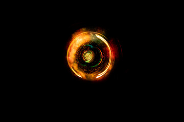 Abstract light circular nebula with light dust and clouds. Circular energy field with burning effect and black background. Warm color with orange and yellow in rotating lights