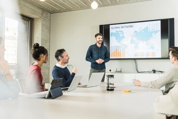 Young businessman leading a presentation in boardroom