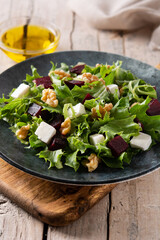 Beetroot salad with feta cheese,lettuce and walnuts on rustic wooden table	