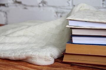 Stack of books and a cozy sweater near