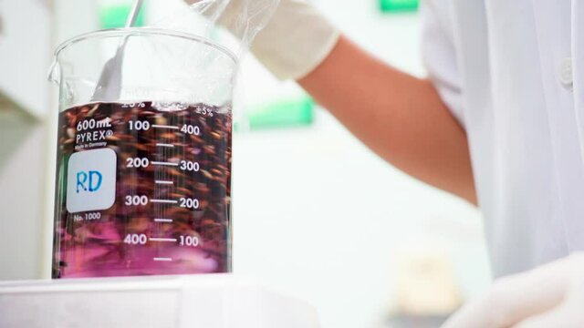 Close up researcher using laboratory stirrer Rice solution in beaker slow motion 100fps