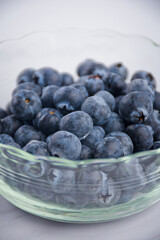 Blueberry fruit in glass cup on white table background,Close-up