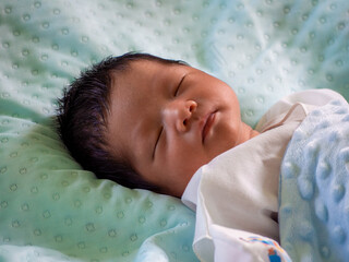 baby sleeping on turquoise mattress