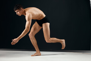 Fototapeta premium male bodybuilder nude muscular body in black panties posing Studio