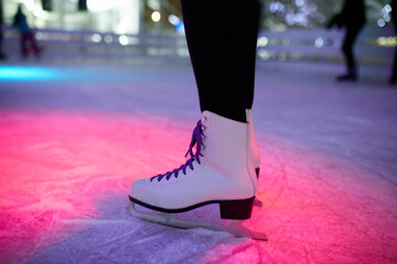 Leg of woman wearing ice skates standing on an ice rink