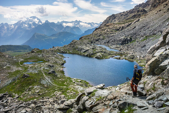Man hiking by lake at Western Rhaetian Alps, Sondrio, Italy