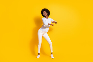 Fototapeta na wymiar Full size photo of optimistic cool short hair lady look empty space dance wear white pullover trousers isolated on yellow background