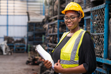 Engineers or technicians are inspecting auto parts in warehouses and factories. African american woman holding a flipchart in parts warehouse.