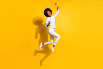 Fototapeta na wymiar Full body profile portrait of delighted dark skin person fists up open mouth celebrate isolated on yellow color background