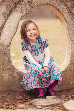 Portrait of laughing little girl wearing dress with floral design