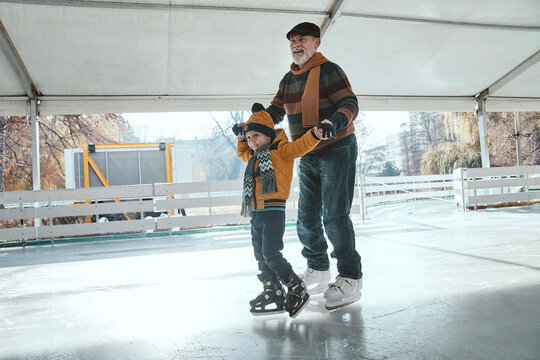 Grandfather and grandson on the ice rink, ice skating