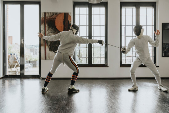 Fencers practicing fencing in loft
