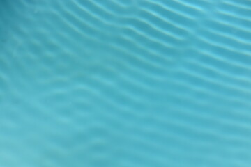 Obraz premium Blurred defocused pool water with ripples. Background, abstract, pool, holidays, business, relaxation concept. Calming rhythms.