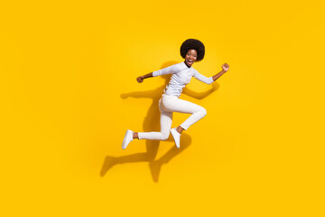 Fototapeta na wymiar Full length profile side photo of trendy brunette afro american girl jump up run isolated on yellow color background