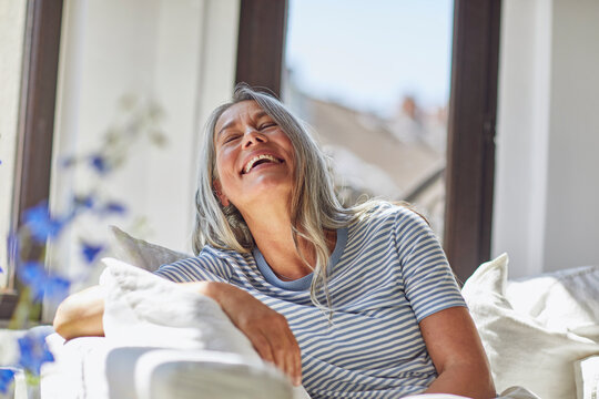 Happy woman relaxing on sofa in living room