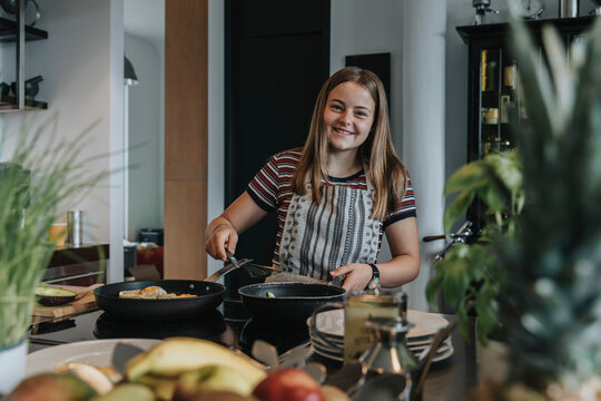 Teenage girl preparing healthy lunch in kitchen