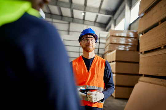 Worker in factory warehouse holding tablet