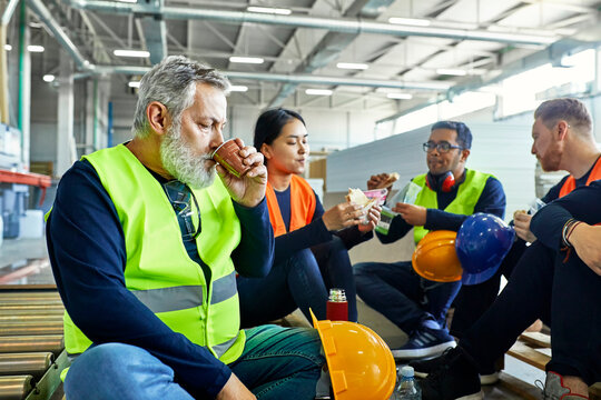 Workers in factory having lunch break together