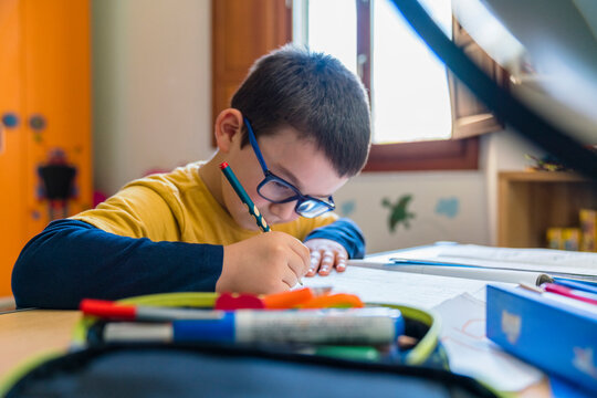 Boy writing in book during homeschooling
