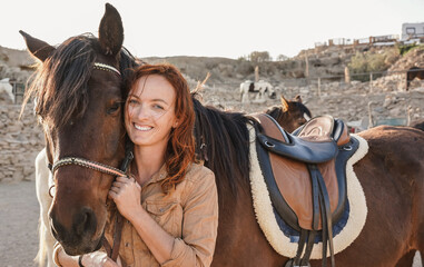 Young farmer woman playing with her horse at farm ranch - Focus on female face