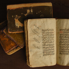 Stack of open ancient books in Arabic. Old Arabic manuscripts and texts. Top view