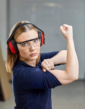 Portrait of female worker flexing her muscles