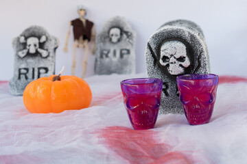 table set for halloween night with grave pumpkins and shotguns on a bloody white tablecloth
